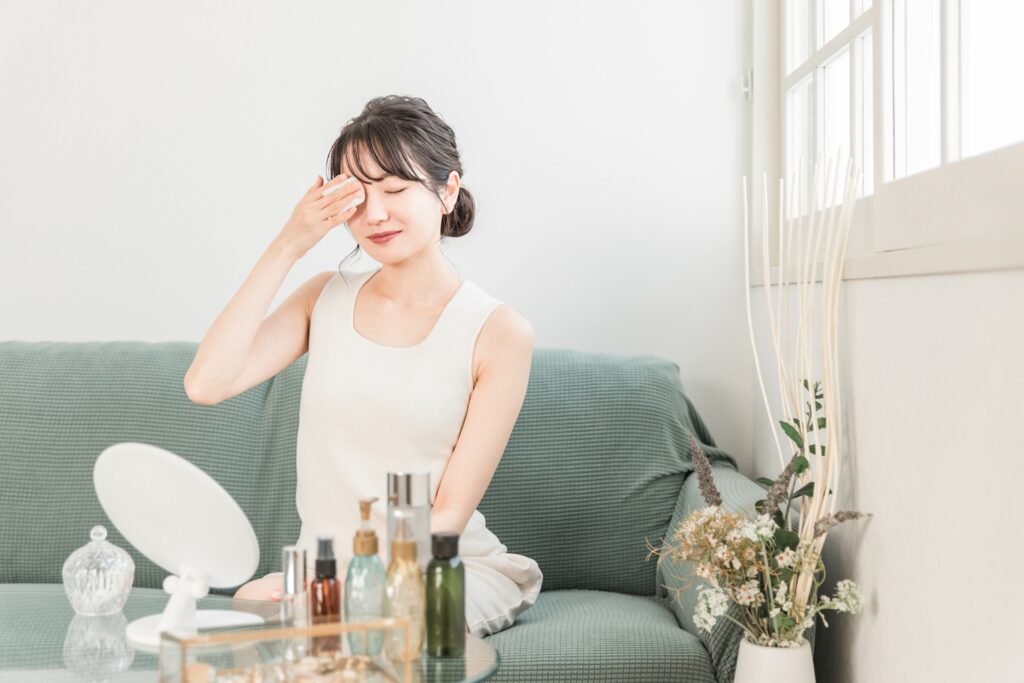 メイクをコットンを使って落とす女性