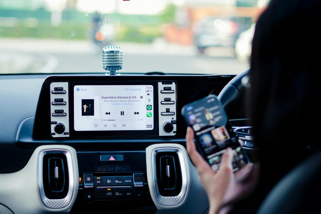 運転席でスマホを見る女性の画像